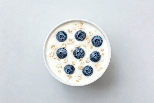 Yogurt with blueberries and oat flakes in a white bowl