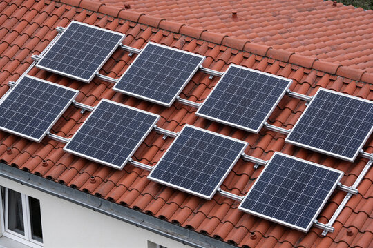 Solar panels mounted on a red tiled house roof