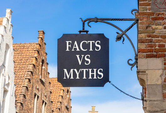 Facts vs versus myths words symbol. Concept words Facts vs Myths on beautiful black road sign. Beautiful blue sky Brugge street background. Business and facts vs versus myths concept. Copy space.