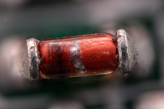 Macro close-up of a diode on an orange printed circuit board.