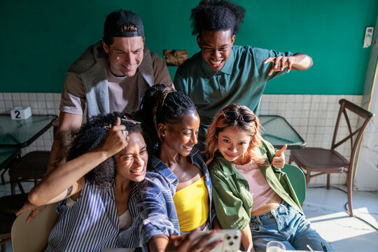 Cheerful people snapping selfies at a restaurant