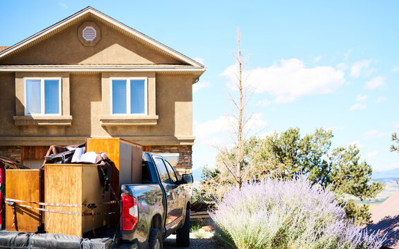 Pickup truck loaded with furniture outside house