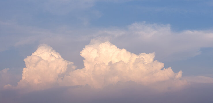 Golden hour cumulus cloud against blue sky