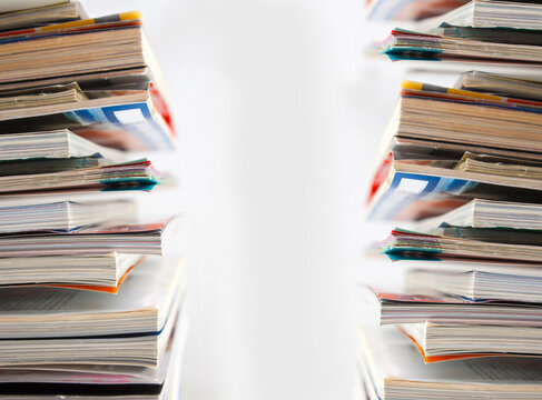  Primer plano de p&aacute;ginas de revistas y libros apiladas. Vista de primer plano extrema de p&aacute;ginas de revistas abiertas apiladas en un espacio brillante.