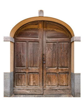 Ancient dark brown wooden entrance door with a double panel design set in traditional arched stone and plaster frame of old classic European building - cut out 
