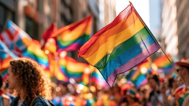Rainbow flags waving at a Pride parade in a city street